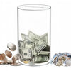 A clear acrylic piggy bank filled with coins and bills, next to a pile of coins and several cats.
