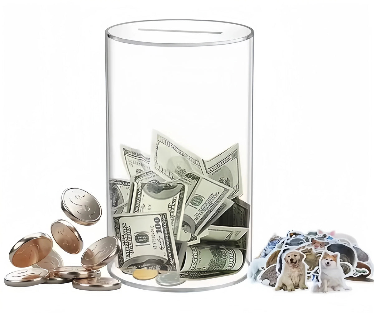 A clear acrylic piggy bank filled with coins and bills, next to a pile of coins and several cats.
