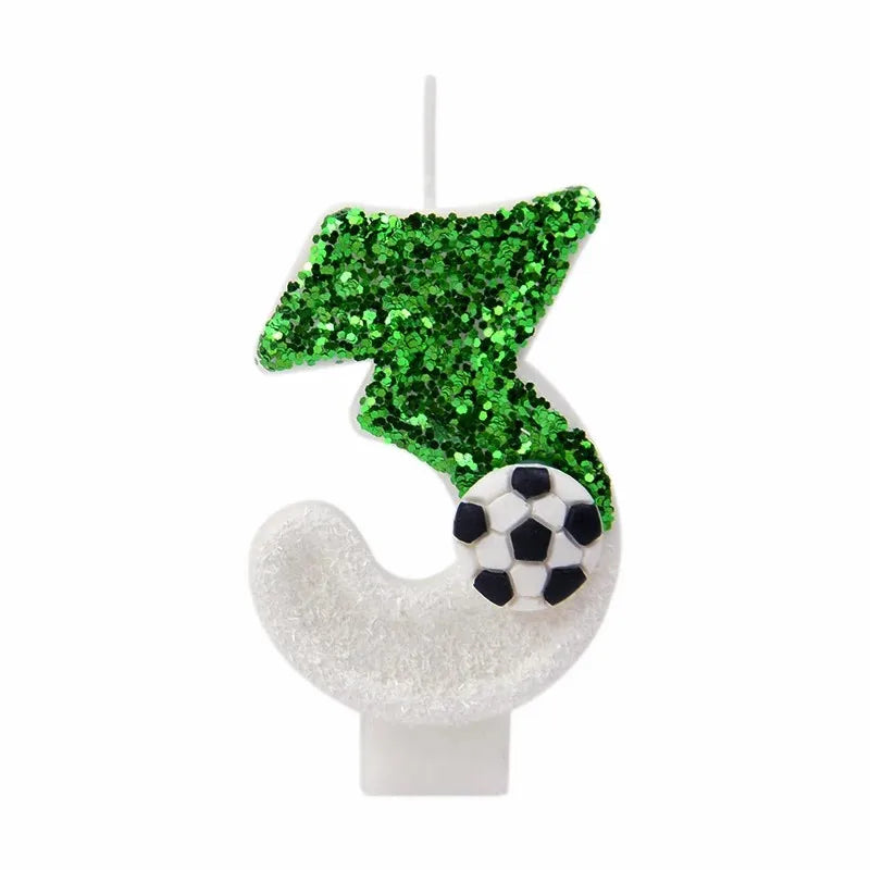 A white candle shaped like a soccer ball with a green glittery tree on top.