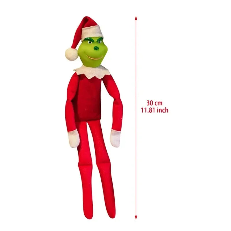 Une figurine d'elfe vert en peluche vêtue d'un costume rouge, d'un chapeau et d'une barbe blancs.