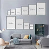 A set of nine framed canvas wall art prints in various sizes displayed on a gray wall above a modern sofa.