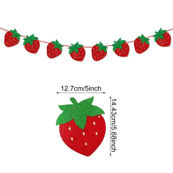 A string of red strawberry ornaments used as a banner decoration for a birthday party.
