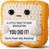 A handmade crochet baseball bat doll in yellow and white with a graduation message card.