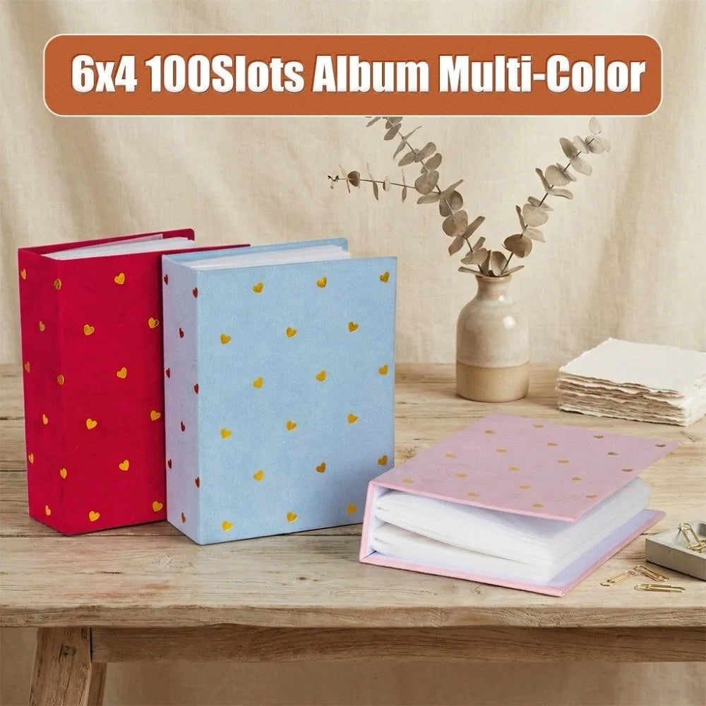 A set of six 6x4 photo albums in multi-color designs, including red, light blue, and pink, displayed on a wooden table.