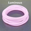A stack of ten luminous pink silicone bracelets arranged in a circular pattern.
