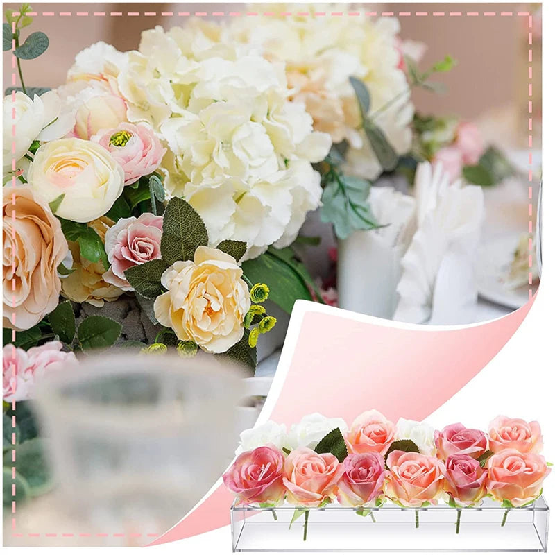 A pink and cream floral arrangement displayed in an acrylic rectangular vase with multiple openings.