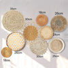 A collection of round boho straw wall hangings in various sizes and shades, including natural beige, tan, and light brown.