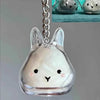 Clear glass rabbit charm keychain with a silver chain and a small, light-colored inner detail.