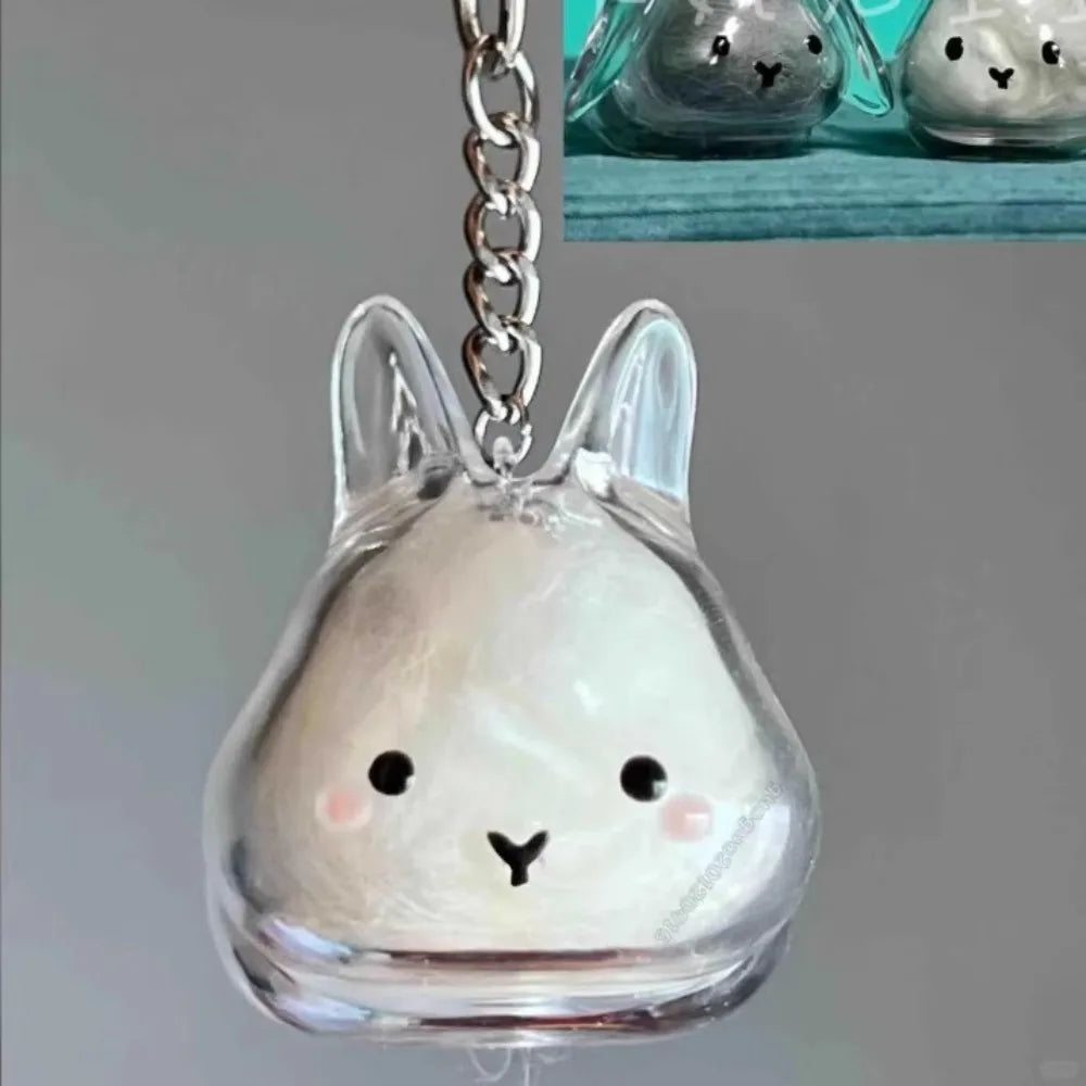 Clear glass rabbit charm keychain with a silver chain and a small, light-colored inner detail.