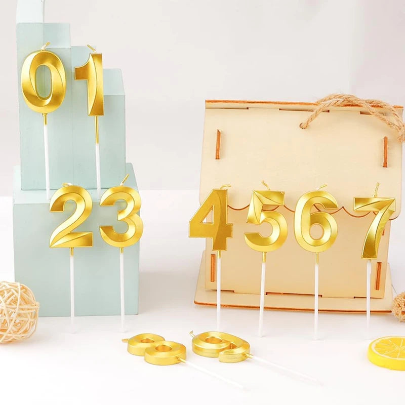 Gold numbered candles 01, 23, 4567 displayed on light blue and beige blocks for celebrations