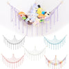 A colorful cotton hammock featuring various stuffed animals and plushies hanging from a light-colored frame.