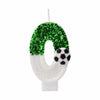 White candle shaped like the number zero covered in green glitter and a soccer ball design