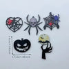 Un set de diez colgantes de acrílico de Halloween con arañas, calaveras y murciélagos en varios colores como negro, plata y a