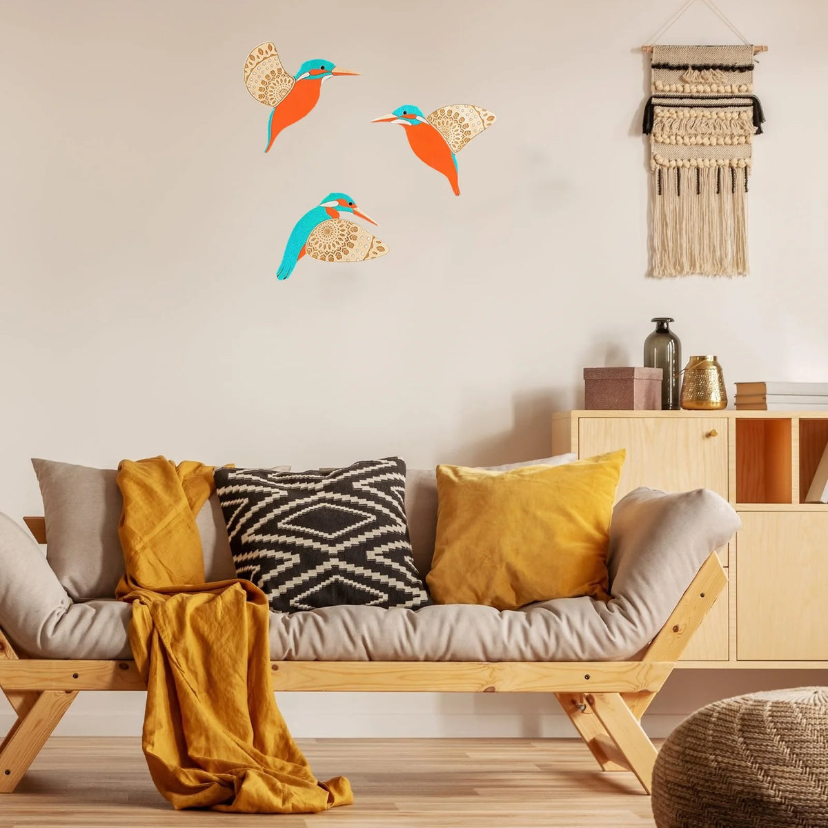 Three vintage wooden bird wall decorations featuring orange and blue colors displayed on a light wall.