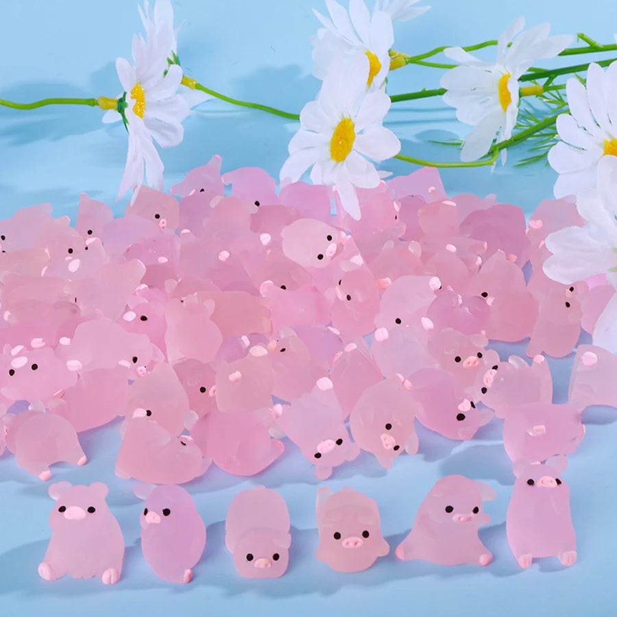 A pile of pink glow-in-the-dark mini pig figurines scattered on a light blue background with white flowers.