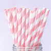 A bundle of pink and white striped paper drinking straws in a glass container.