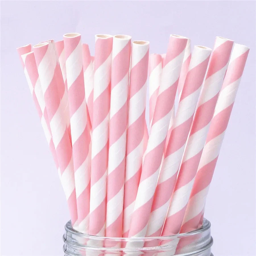 A bundle of pink and white striped paper drinking straws in a glass container.