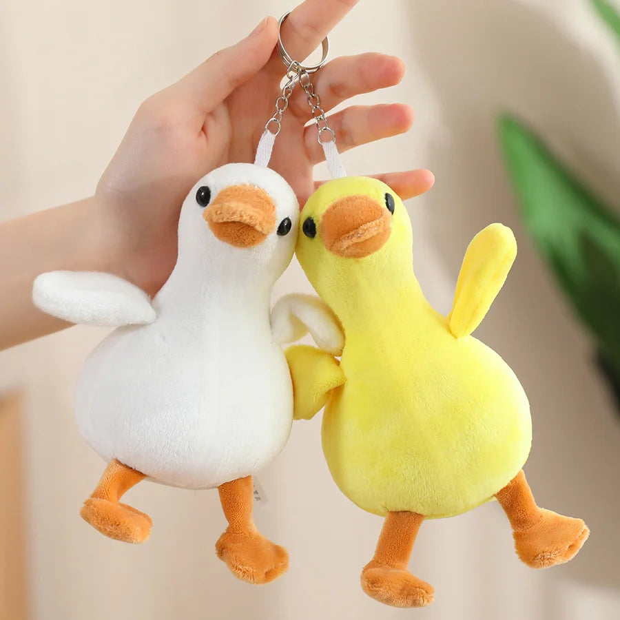 A white duck plush keychain pendant with a yellow duck plush attached to a silver chain.
