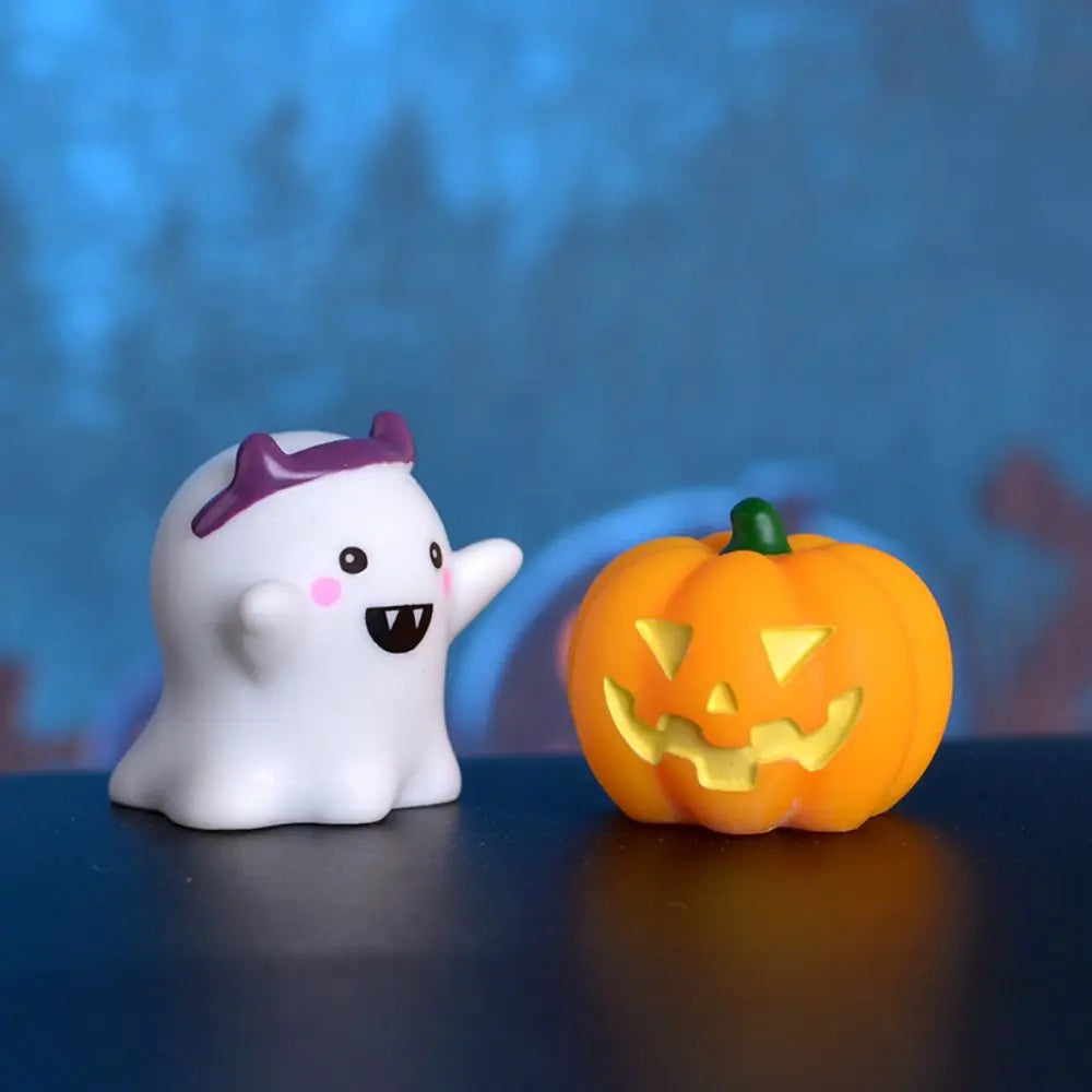 A white resin craft miniature ghost with purple accents next to an orange carved pumpkin.
