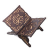 Handcrafted wooden Quran book stand with intricate arabesque design featuring dark wood and gold accents.