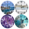 Four round wall clocks showing different styles including a seascape, abstract lines, floral designs, and blue watercolor tex