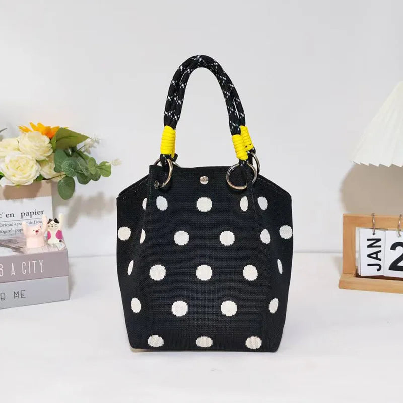 Black canvas shoulder bag with white polka dots and yellow trim
