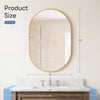Oval wall mirror with a gold metal frame hanging above a marble vanity countertop.