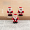 A set of festive Christmas resin decor featuring two Santa figures with white beards and red suits.