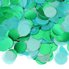 A pile of round tissue paper confetti dots in various shades of green and teal.