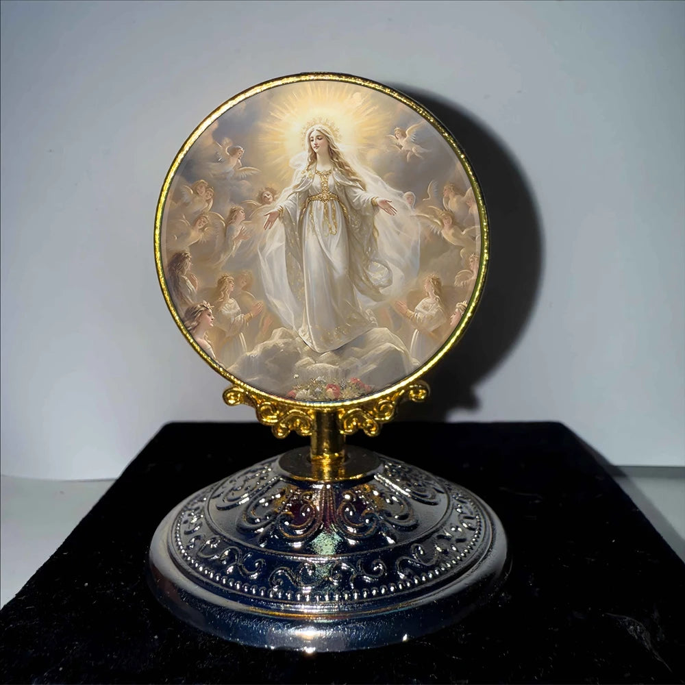 A golden framed religious ornament featuring a depiction of the Virgin Mary with a radiant halo and surrounding figures.