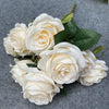 A bouquet of nine realistic white silk roses arranged on a gray background.