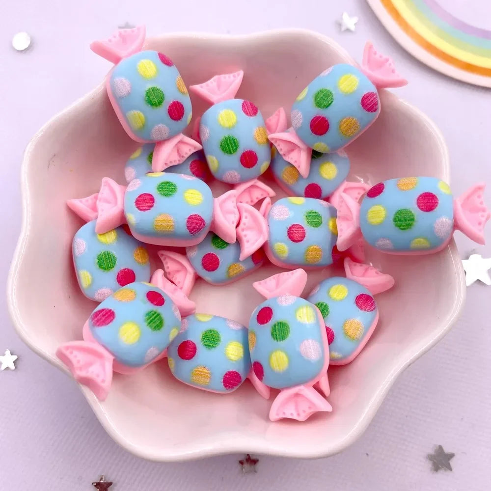 A pink dish holds colorful blue and pink resin cabochons with glitter dots for crafting projects.