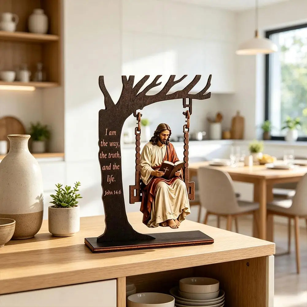 A wooden desk ornament depicting Jesus reading a Bible in a tree branch.