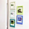 A set of five decorative photo frames in various shades of green and blue mounted on a white surface.