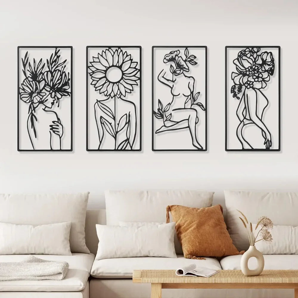 A set of four black and white line art prints depicting female profiles and floral elements on a white wall.