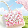 A pink and white cartoon animal keyboard keycap fidget toy is shown attached to a white bag in an outdoor setting.