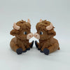 A small, brown statue of a Highland cow with horns and large eyes.