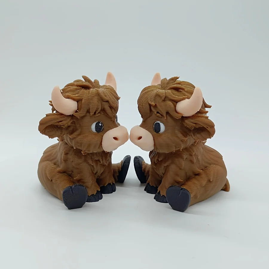A small, brown statue of a Highland cow with horns and large eyes.