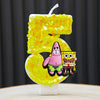 A yellow cake candle shaped like the number 5, featuring SpongeBob SquarePants characters.