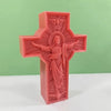 A pink silicone mold of a religious Jesus cross with an angel above and a depiction of Jesus in the center.