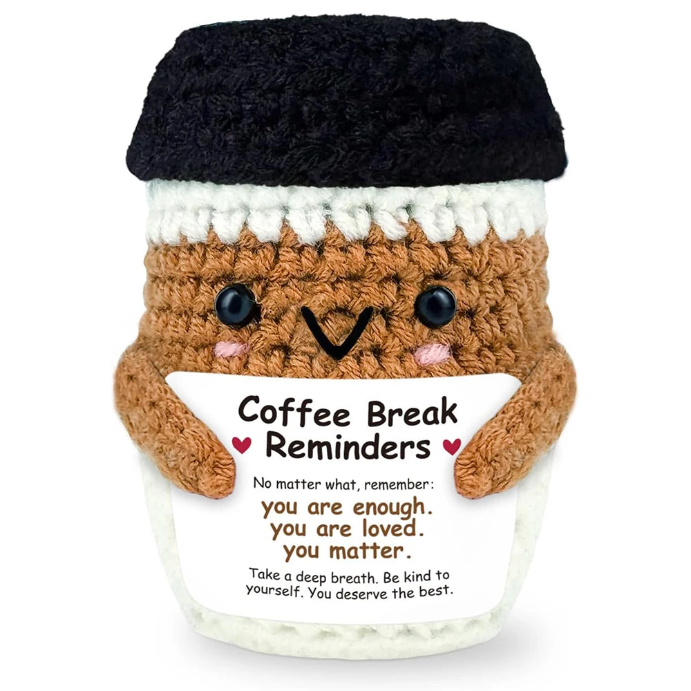 Handwoven knitted coffee cup cozy with a brown doll decoration and text reminding to be enough