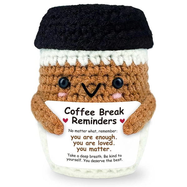 Handwoven knitted coffee cup cozy with a brown doll decoration and text reminding to be enough