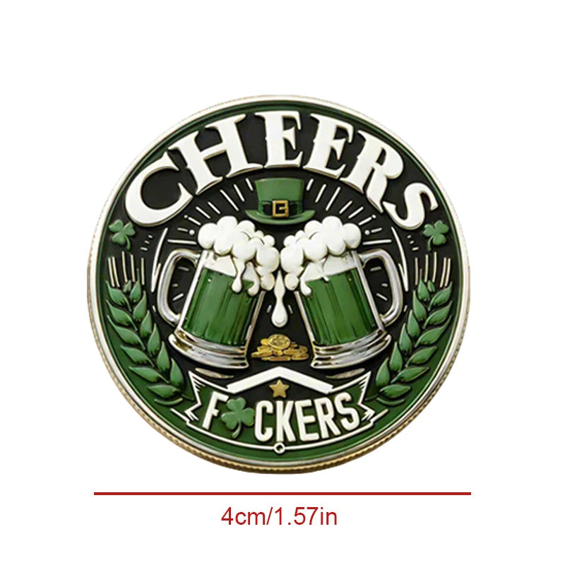 A round green coin featuring a silhouette of a beer mug and laurel leaves with the text Cheers and Fckers.