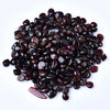 A pile of deep burgundy natural garnet crystal chips for jewelry and decor.