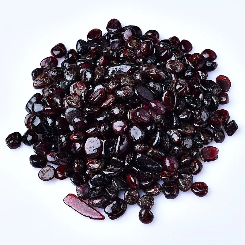 A pile of deep burgundy natural garnet crystal chips for jewelry and decor.