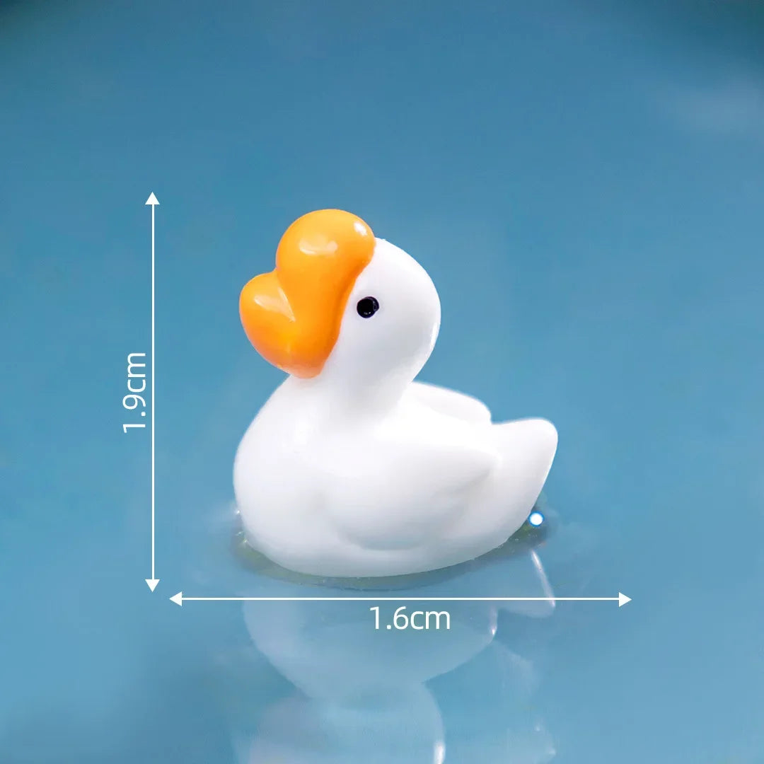 Sculpture de canard en résine blanche avec bec orange flottant sur une surface bleue.