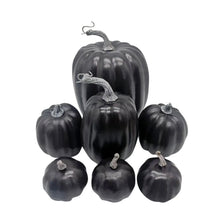 A set of seven artificial black pumpkins for fall and Halloween decoration.