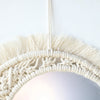 Boho macrame round wall mirror with a natural fiber fringe and woven texture