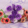 A bouquet of handcrafted soap roses in shades of purple and white, tied with sheer purple ribbon.