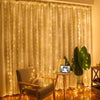 A sheer cream curtain decorated with warm white fairy lights, illuminated in a room setting.